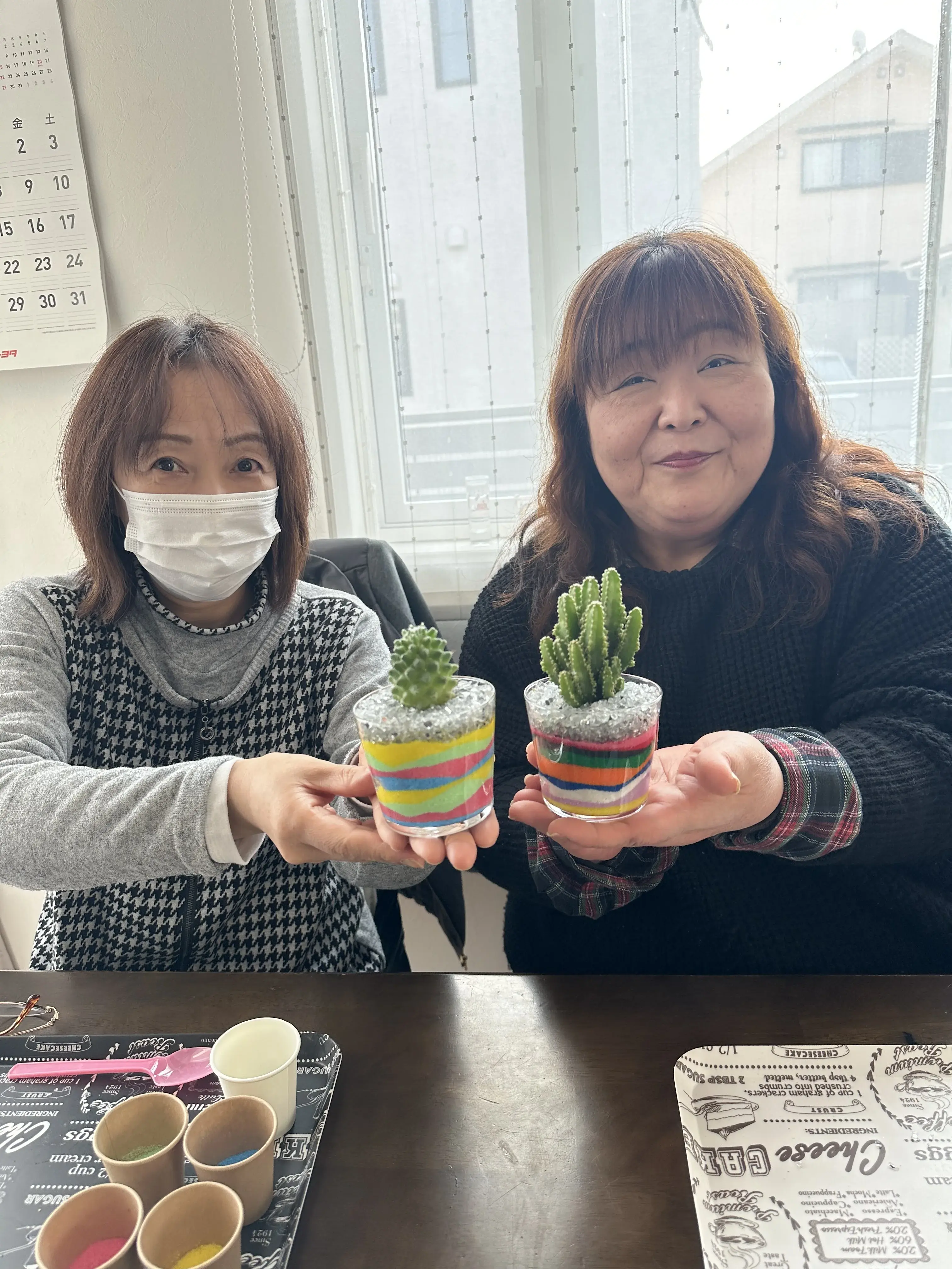 サンドアートと観葉植物・サボテンのワークショップで完成した作品を持つ参加者