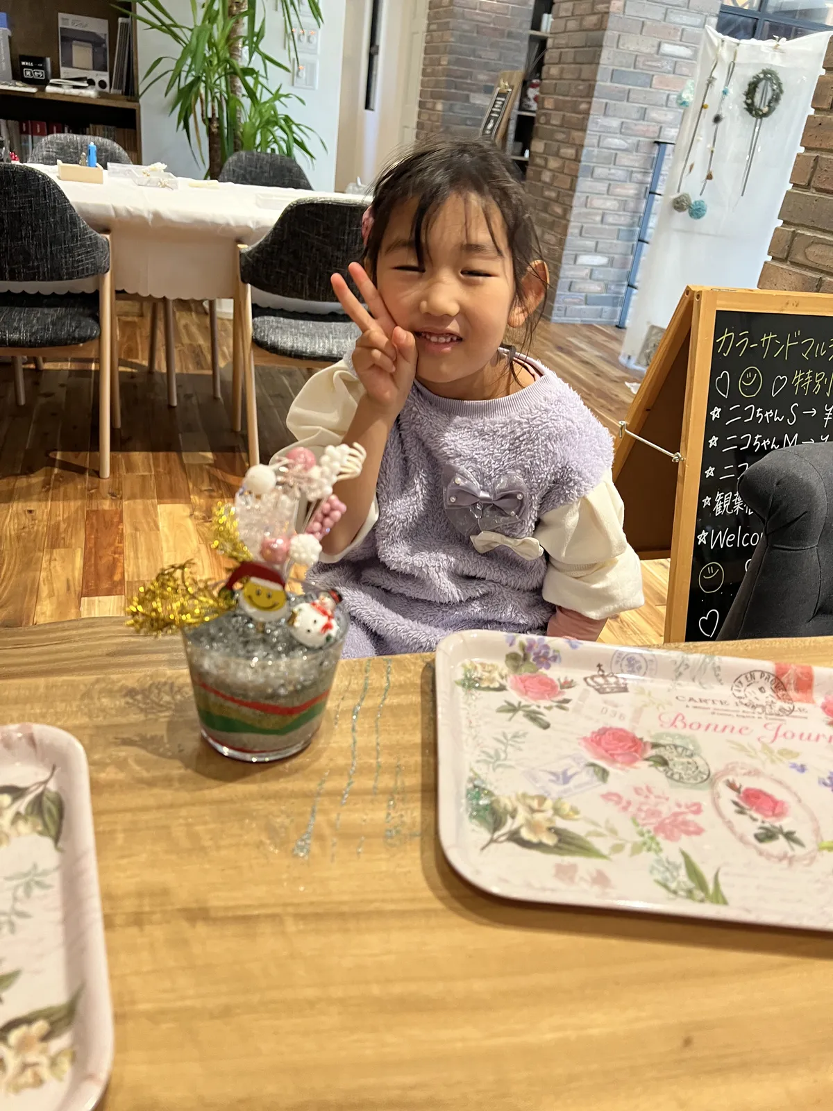 ピースサインで笑顔の女の子と手作りクリスマスサンド
